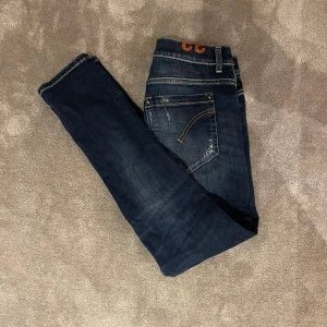 Mörkblå skinny jeans från George - Snygga mörkblå skinny jeans från dondup med slitna detaljer. Dem är i storlek 33 men är små i storleken. Jeansen är i mycket bra sckic. Priser kan absolut förhandlas vid snabb affär.