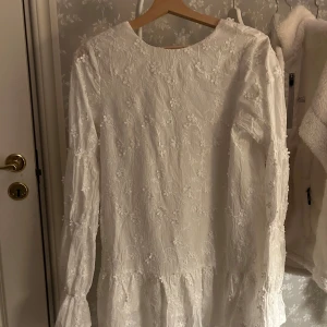 Vit klänning - Kort vit klänning med blomdetaljer från nakd, perfekt för studenten!💖strl 36