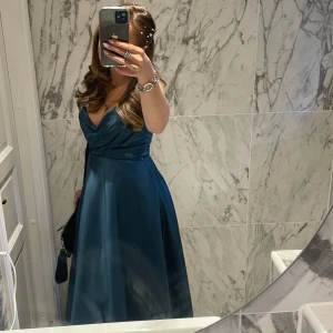 Balklänning från JJ's House - Säljer min balklänning från JJ's House med v-ringad design och smala axelband. Klänningen har en  slits framtill. Använd 1 gång. Jag är 164 lång 