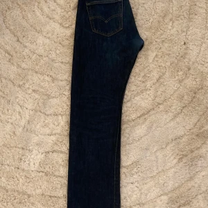 Levis 501 jeans - Klassiska Levis 501 jeans i mörkblå denim. De har en rak passform och knappgylf. Perfekta för en tidlös stil.