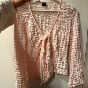 Topp med knytning - Säljer en rosa topp med knytning från Ginatricot i stl. S. Skriv för fler frågor:)🥰