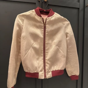 Bomberjacka - Såå cool bomberjacka i guld med vinröda detaljer. Passar en xs/s 