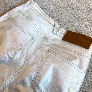 Silvriga jeans - Så festliga silvriga jeans från Carin Wester. Knappt använda. Ganska mjuka i materialet. Kommer ej till användning längre. 