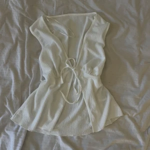 Vit topp - stilren vit topp med knytband vid brösten. Suuper fin. S/M/L, man kan knyta hur hårt man vill. Aldrig använd 