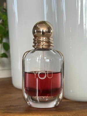 Emporio Armani Power of You parfym - Emporio Armani Power of You parfym i en elegant glasflaska med rundad form och guldfärgat klotformat lock. Doften har en djup röd färg som syns genom det klara glaset. Flaskan har stilrena detaljer och känns lyxig och modern.