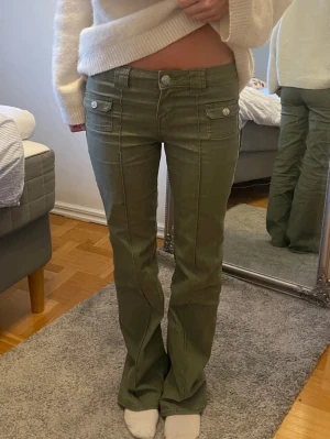 Olivgröna jeans med fickor - Snygga olivgröna jeans med dekorativa fickor framtill med knappar. Jeansen är i storlek 36 och nästan aldrig används. Köptes på Hm och säljer då dom är lite för korta för mig som är 178cm.