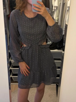 Mörkblå prickig klänning med öppen rygg - Söt mörkblå kortklänning med vita prickar, långärmad och med transparenta ärmar. Klänningen har öppen rygg och cut-out detaljer i midjan samt volang nedtill. Från Hm men jag har klippt av lappen🫐💙💙