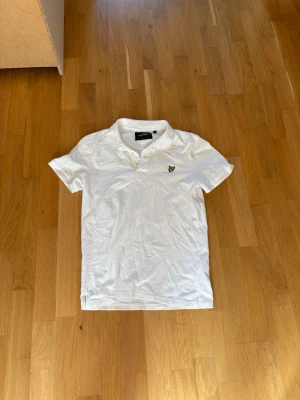 Vit pikétröja med broderad logga - Säljer en lyle&scott pike i storlek M. Säljer dem billigt för den inte passar.