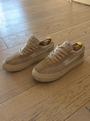 SWC Sneakers  - Snygga beige sneakers med ovandel i mocka och meshdetaljer. Skorna har en låg siluett, vita sidor och matchande beige snören. Stepney Workers Club 