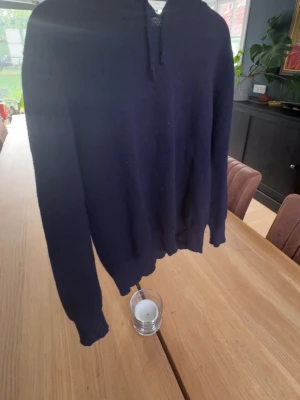 Kashmir tröja  - En enkel och stilren mörkblå hoodie med huva och dragsko. Hoodien har långa ärmar och ribbade muddar vid ärmslut och nederkant. Perfekt för en avslappnad look och passar till det mesta i garderoben. Från sayless. Priset ej hugget i sten, dm för frågor 
