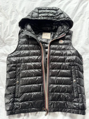 Moncler väst - Säljer en sällsynt dunväst från Moncler i storlek 2 (s/m). Färg: Svart |  Mycket fint skick 9/10, knappt några tecken på användning. Självklart äkta! Nypris: 10 000. Mitt pris: 4 500. Priset är inte hugget i sten! Vid fler frågor och bilder kom privat.