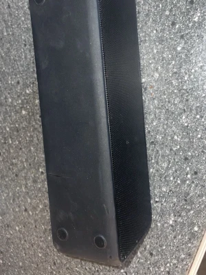 Svart bärbar högtalare med gummiyta - Snygg svart bärbar högtalare med avlång form och gummiyta. Högtalaren har tydliga knappar på ovansidan för volym, play/pause och power. Fronten är täckt av ett metallgaller som skyddar högtalarelementen. Perfekt för att ta med sig överallt.