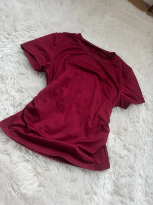 vinröd  kortärmad t-shirt - En enkel och stilren vinröd t-shirt med korta ärmar och rund hals. Perfekt basplagg i garderoben och lätt att matcha med olika outfits. Tillverkad i mjukt material för skön känsla hela dagen.