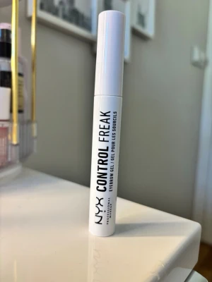 NYX Control Freak ögonbrynsgel - NYX Control Freak är en transparent ögonbrynsgel i en vit tub med svart text. Perfekt för att forma och fixera brynen hela dagen. Enkel att applicera med borste och ger ett naturligt resultat utan att kännas klibbig. Aldrig använd. Köptes för 120kr