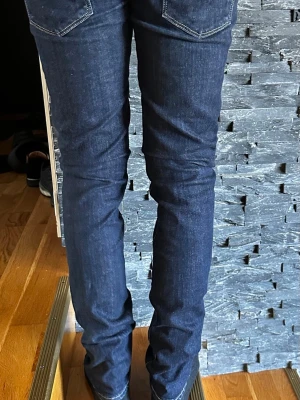 Mörkblå slim fit jeans Slight curve W 29 L 32 - Säljer ett par mörkblå slim fit jeans med klassisk femficksdesign och kontrastsömmar. Jeansen har en smal passform och är tillverkade i ett stretchigt denimtyg som sitter snyggt längs benen. Perfekta för en clean och stilren look. W29 L 32