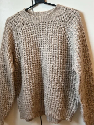 Beige stickad tröja med strukturmönster - Endast upphämtning 🤍 Säljer en beige stickad tröja med grovt strukturmönster och rund hals. Tröjan har långa ärmar och ribbade muddar vid ärmslut och nederkant. Perfekt för lager på lager och riktigt mysig till hösten och vintern.