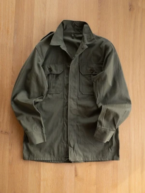 Military Officers Shirt, size M - Stilren olivgrön overshirt i bomull med två stora bröstfickor med lock och knappar. Klassisk krage och raka ärmar ger en avslappnad look. Perfekt lager-på-lager-plagg för dig som gillar utility-stil.