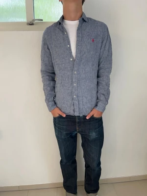 Linneskjorta från Polo Ralph Lauren - En stilren skjorta i 100% linne från Polo Ralph Lauren. Skjortan har lång ärm och en liten röd broderad Polo logga på bröstet. Perfekt för en dag i skolan eller en utekväll! Hör av dig vid frågor!🙌