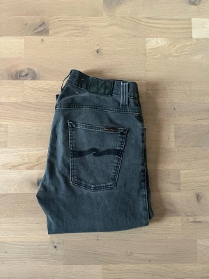 Nudie Grim Tim  - Säljer ett par nudies i modellen grim Tim. Dem har en klassisk regular passform vilket är mitt emellan straight och slim fit. Storlek är W33 L34