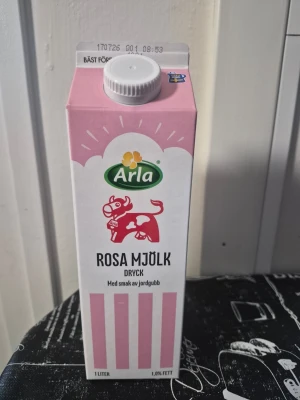 Tom förpackning:Arla rosa mjölkdryck jordgubb - Säljer en tom förpackning av Arla rosa mjölkdryck med smak av jordgubb. Kartongen är vit och rosa med illustration av en rosa ko och dekorativa ränder. Perfekt till samlare. 