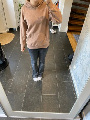 Brun hoodie med huva och magficka - Säljer en brun hoodie med klassisk huva och stor magficka framtill. Hoodien har ribbade muddar vid ärmslut och nederkant. Perfekt för en avslappnad och chill stil. Materialet känns mjukt och bekvämt, passar perfekt till jeans eller mjukisbyxor.