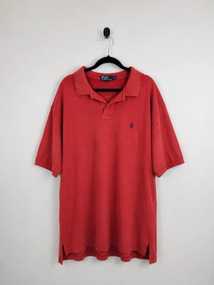 Vintage Polo Ralph Lauren Piké XXL Faded Coral Röd Polo Pony Herr 90s Y2K - • Storlek: XXL • Färg: Korall röd • Passform: Relaxed Fit  • Krage: Klassisk pikékrage • Material: 100% bomull  Skick: Plagget är i väldigt fint skick med en fläck bakom nacken. Eventuella anmärkningar anges alltid tydligt i beskrivningen och visas på bilderna.  Nypris: Cirka 1 500 kr.  📦 Skickas snabbt och packas omsorgsfullt. 💬 Hör gärna av dig om du har frågor eller vill se fler bilder. 🤝 Samfrakt erbjuds vid köp av flera plagg – kika gärna in mina andra annonser!• Storlek: XXL • Färg: Korall