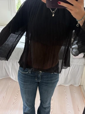 Svart topp ifrån Zara - Supersnygg topp ifrån Zara med lager, man kan knyta den i ryggen/nacken.