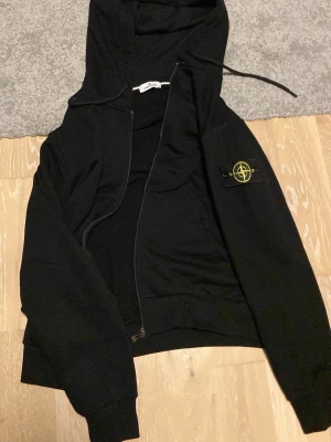 Svart hoodie från Stone Island - Säljer en stone Island zip hoodie för den va för stor jag är 174 det är storlek L. Den passar perfekt för typ 180cm och uppåt. Qr koden fungerar man kommer in på stone island hemsida. Använd 1 gång!