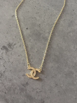 CC halsband  - 14k guldpläterat halsband med CC logga med glittrande stenar. Rostfritt 💛