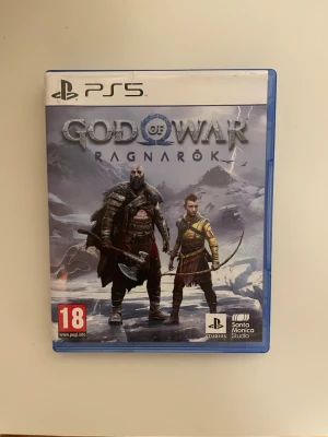 God of War Ragnarök PS5 spel - Säljer God of War Ragnarök till PlayStation 5. Spelet kommer i ett blått plastfodral med omslagsbild på Kratos och Atreus i en snöig miljö. Inuti finns spelets skiva och informationshäfte. Perfekt för dig som gillar action och äventyr.