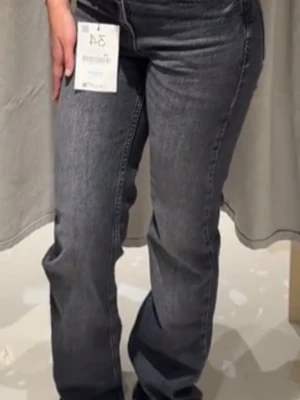 Grå raka jeans med tvättad look - Säljer ett par grå Strandivarius jeans med rak passform och snygg tvättad effekt, i modellen D98. Jeansen har klassisk femficksdesign, normal midja och dragkedja med knapp. Materialet är denim i bomull och de har en avslappnad vibe som passar till det mesta. Aldrig använt med prislapp. Bilden med byxan är tagen från TikTok med samma byxa.🫶🫶