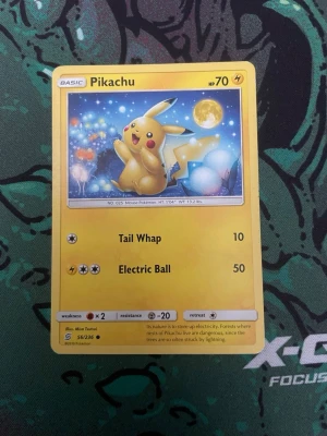 Pikachu Pokémonkort 56/236 - Säljer ett samlarkort från Pokémon med Pikachu-motiv, nummer 56/236. Kortet har gul ram och färgglad illustration med Pikachu under en måne. Text och symboler i svart och gult. Perfekt för dig som gillar Pokémon eller samlar på kort. Skulle tro psa 8