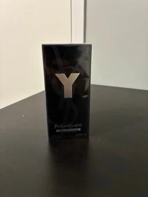 Yves Saint Laurent Y Eau de Parfum 100ml - Yves Saint Laurent Y Eau de Parfum i elegant svart förpackning med stor silverfärgad Y-logga. Flaskan rymmer 100 ml och har en modern, stilren design som känns lyxig och tidlös. Perfekt för dig som gillar exklusiva dofter och vill ha något som sticker ut.