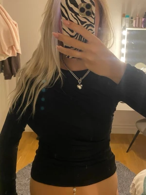 Svart långärmad topp - Svart tight långärmad topp med en snygg detalj över axeln