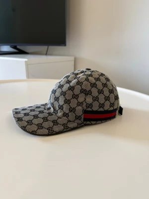 Gucci-keps med GG-monogram - Authentic Gucci-keps i utmärkt skick (9/10).  En tidlös lyxaccessoar som har använts sparsamt och tagits väl om hand. Kepsen är ren och har endast minimala tecken på användning.  • 100 % äkta Gucci • Utmärkt skick (9/10) • Ren och redo att användas • Förvarad omsorgsfullt • Snabb leverans  Tveka inte att skicka ett meddelande om du har frågor eller vill ha fler bilder. Rimliga bud är välkomna.