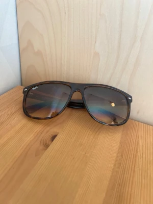Bruna Ray-Ban pilotbågar solglasögon - Snygga solglasögon från Ray-Ban med klassisk pilotform och bruna bågar. Glasen har en lätt tonad effekt som ger en cool vibe. Perfekta för soliga dagar och ger en tidlös look till din outfit.