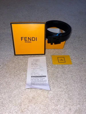 FENDI bälte  - Hej, säljer detta Fendi bälte då det inte var min stil, fick den som en gåva av mina föräldrar. Det är ett stilrent svart bälte med svart FENDI logga. Bältet kostade runt 3 tusen kronor men är idag värt ännu lite mer då det köptes 2021. Helt oanvänt och kommer med kvitto ett kort samt box! Köptes i Rom 🇮🇹💰