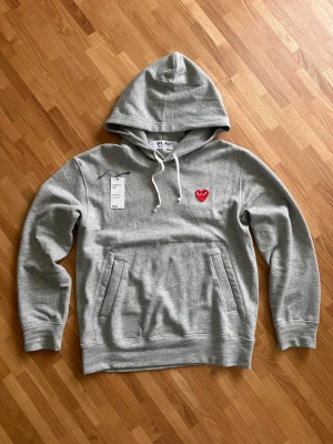 Cdg Hoodie - Säljer en äkta cdg hoodie i topp skick. Använd 3 gånger typ. Verifierad med Vinted där jag köpte den✅ har kvar original tags också. Storlek M passar 175-185. Hör av er vid frågor!