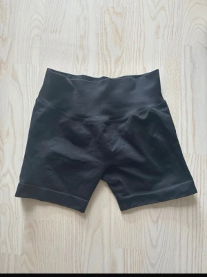 Svarta träningshorts Relode - Säljer ett par svarta shorts från Relode. Shortsen har en tight passform med scrunch och är perfekta för träning eller gym.