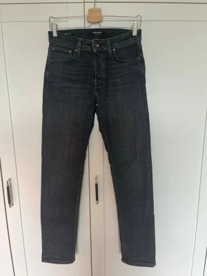 Mörkgrå jeans Jack&Jones - Snygga mörkgrå jeans med rak passform och klassisk femficksdesign. Jeansen har normal midja och är tillverkade i ett robust denimtyg. Perfekta för en clean och stilren look.