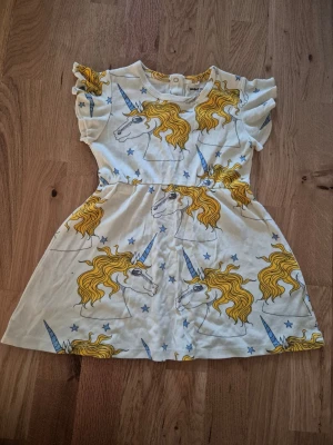 Mini Rodini unicorns - Klänning från Mini Rodini, stl 92-98. Klänningen har korta ärmar med volangdetaljer och rund hals. Knappar bak i nacke. Fint skick, använd fåtal gånger. Hos oss bor inga djur eller rökare