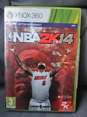 NBA 2K14 till Xbox 360 - NBA 2K14 är ett basketspel till Xbox 360 där du kan spela som NBA-stjärnor och skapa ditt eget lag. Omslaget har en röd bakgrund med en spelare i Heat-tröja. Spelet är i plastfodral och har PEGI 3-märkning. Perfekt för dig som gillar sportspel och basket.
