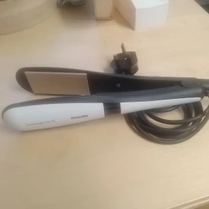 Plattång Philips SalonStraight Pro XL - Plattång från Philips, modell SalonStraight Pro XL. Färgen är svart och vit med keramiska plattor och sladd med EU-kontakt. Perfekt för att styla och räta ut håret snabbt och smidigt. Obs!: Ej svenska kontakter 