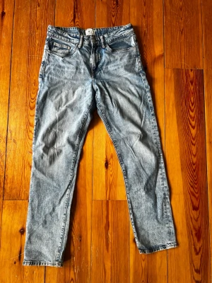 Ljusblå raka jeans med fem fickor 30/32 - Säljer ett par ljusblå jeans med klassisk femficksmodell och raka ben. Jeansen har en snygg tvättad look och är tillverkade i denim. Perfekta för en avslappnad och trendig stil.