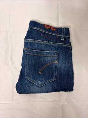 Dondup George jeans 👖  - Snygga blå slim fit jeans med klassisk femficksdesign och kontrastsömmar. Jeansen har en lätt tvättad look och smal passform som sitter tajt längs benen. Tillverkade i denim med stretch för extra komfort. Perfekta för en trendig och avslappnad stil. Storlek w30 väldigt snygga och i väldigt bra skick.