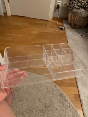 Transparent sminkorganiserare i akryl - Praktisk sminkorganiserare i genomskinlig akryl med flera fack i olika storlekar för att hålla ordning på borstar, pennor och andra skönhetsverktyg. Perfekt för att skapa översikt och struktur på sminkbordet.