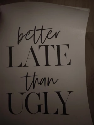 Poster med text 'Better Late Than Ugly' - Snygg poster i vitt med svart text som säger 'better LATE than UGLY'. Perfekt som humoristisk väggdekoration i sovrum, hall eller vardagsrum. Tryckt på papper med stilren och modern design.