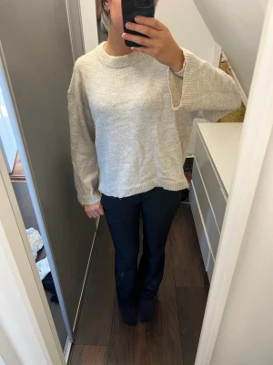 Beige stickad tröja Gina Tricot - Mysig beige stickad tröja från Gina Tricot i storlek Xs. Tröjan har en avslappnad passform, rund halsringning och ribbade muddar vid ärmslut och nederkant. Perfekt för lager på lager och enkel att matcha med olika stilar.
