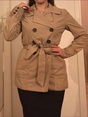Trenchcoat - Trenchcoat i bomullstyg, så den är extra varm och skön. Vintage och kortare.