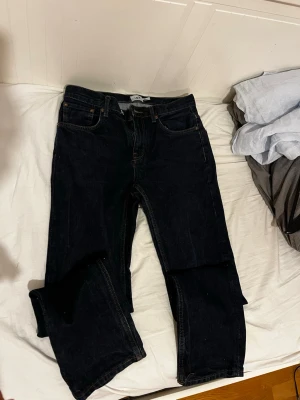 Lager 157 jeans W30L32 - Säljer ett par svarta jeans med rak passform och klassisk femficksdesign. Jeansen har normal midja och är tillverkade i ett robust denimtyg. Passar perfekt till en avslappnad och stilren look.